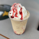 Starbucks' new Frappuccino sitting on Starbucks tabletop with whipped cream and red syrup drizzle